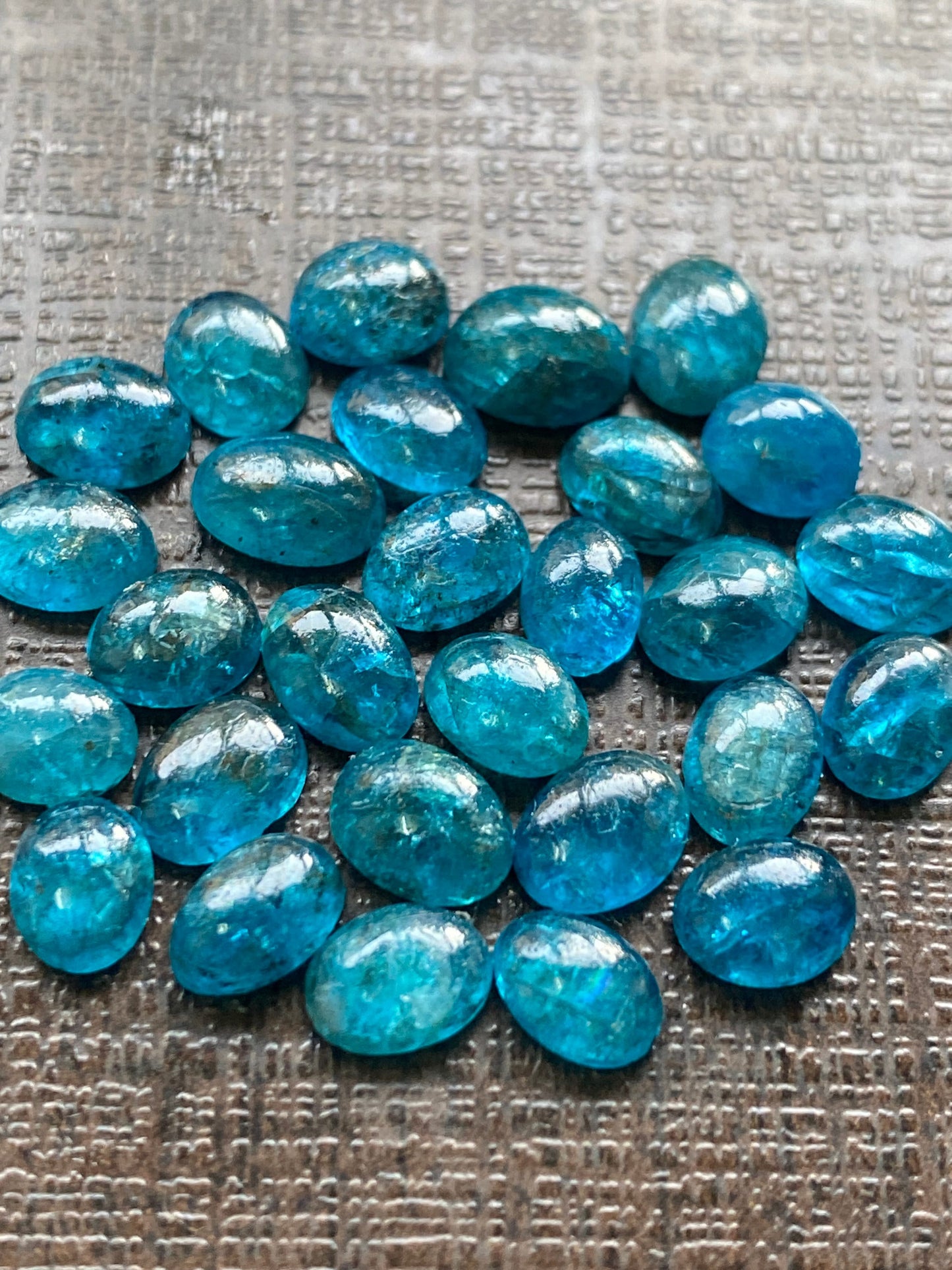 Neon blue apatite flat cabochons oval rounds wholesale lot pcs 28 weight 19.40 carats size 6x4.8mm-6.4x4.5mm electric blue apatite cabochons